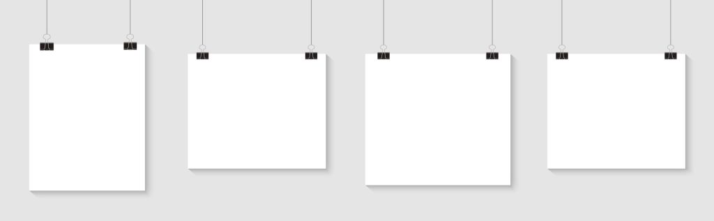 Cuatro carteles en blanco colgados sobre una pared para mostrar un diseño