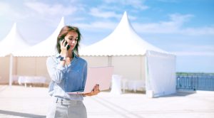 Woman on the phone in front of white event marquees