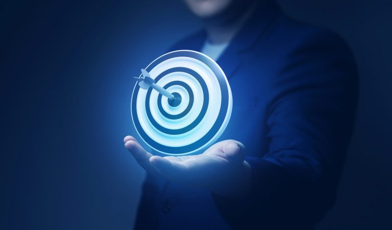 Hand holding a glowing target icon on a blue background