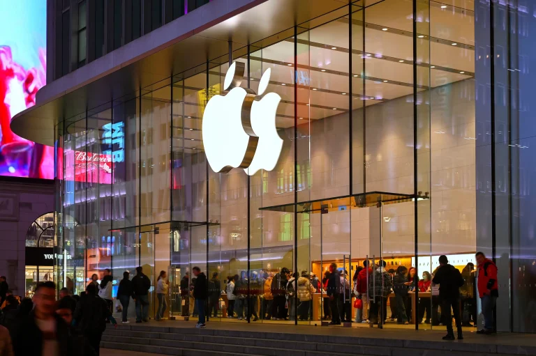 Tienda de Apple iluminada de noche con el logotipo corpóreo