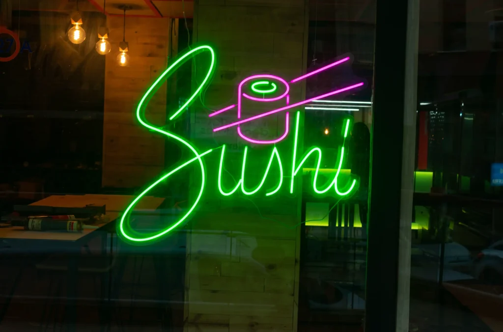 Rótulo de neón verde con la palabra sushi en un restaurante