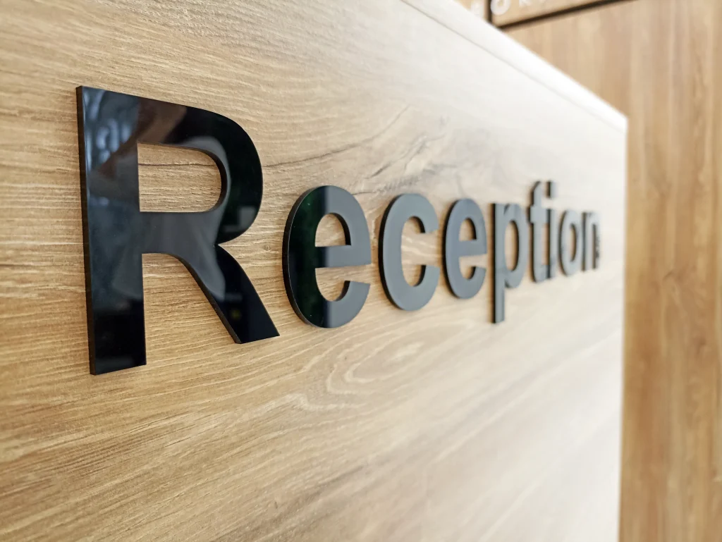 Letras corpóreas con la palabra reception sobre pared de madera