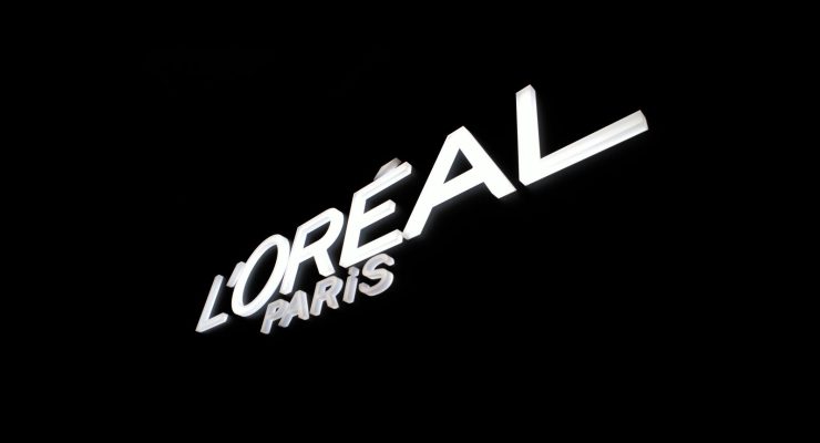 Logotipo corpóreo de L'Oréal Paris sobre pared negra
