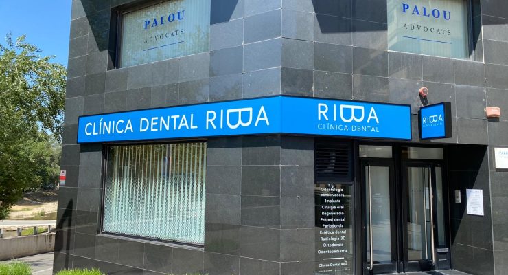 Fachada de la Clínica Dental Palou con rótulo corporativo iluminado